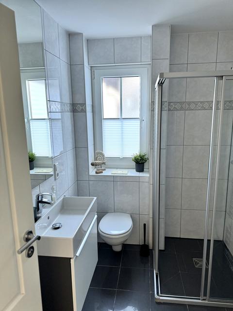 Badezimmer mit Dusche, Waschtisch und WC