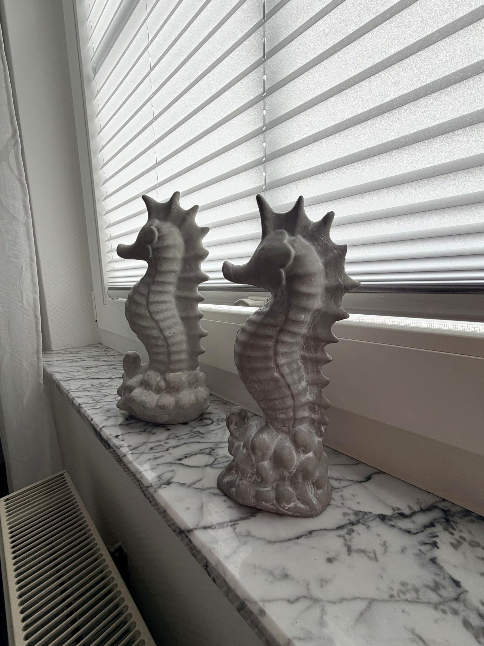 Two ceramic seahorses on the windowsill
