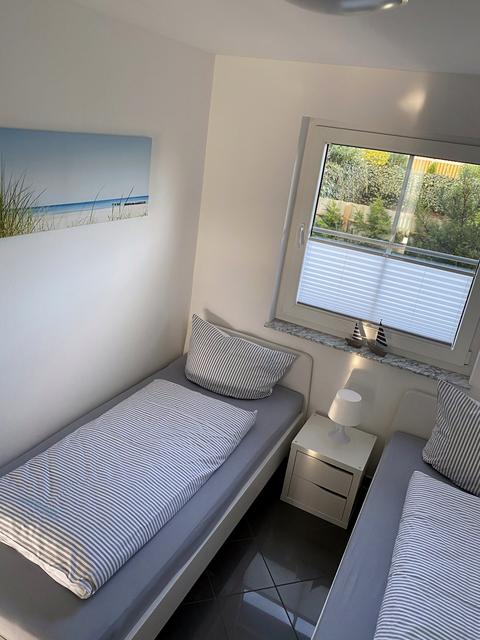 Single beds with bedside table and beach picture