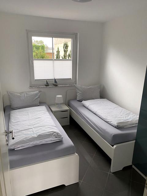 Bright bedroom with two single beds and wardrobe