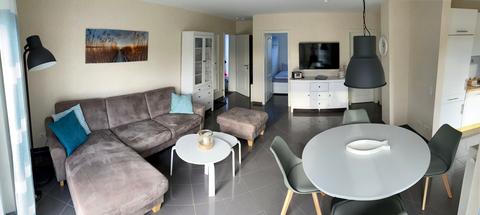 Living area with corner sofa, dining table and large flat screen TV