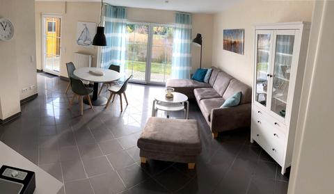 Heller Wohn- und Essbereich der Ferienwohnung Nele in Zempin mit Esstisch, Sofa und bodentiefer Terrassentür